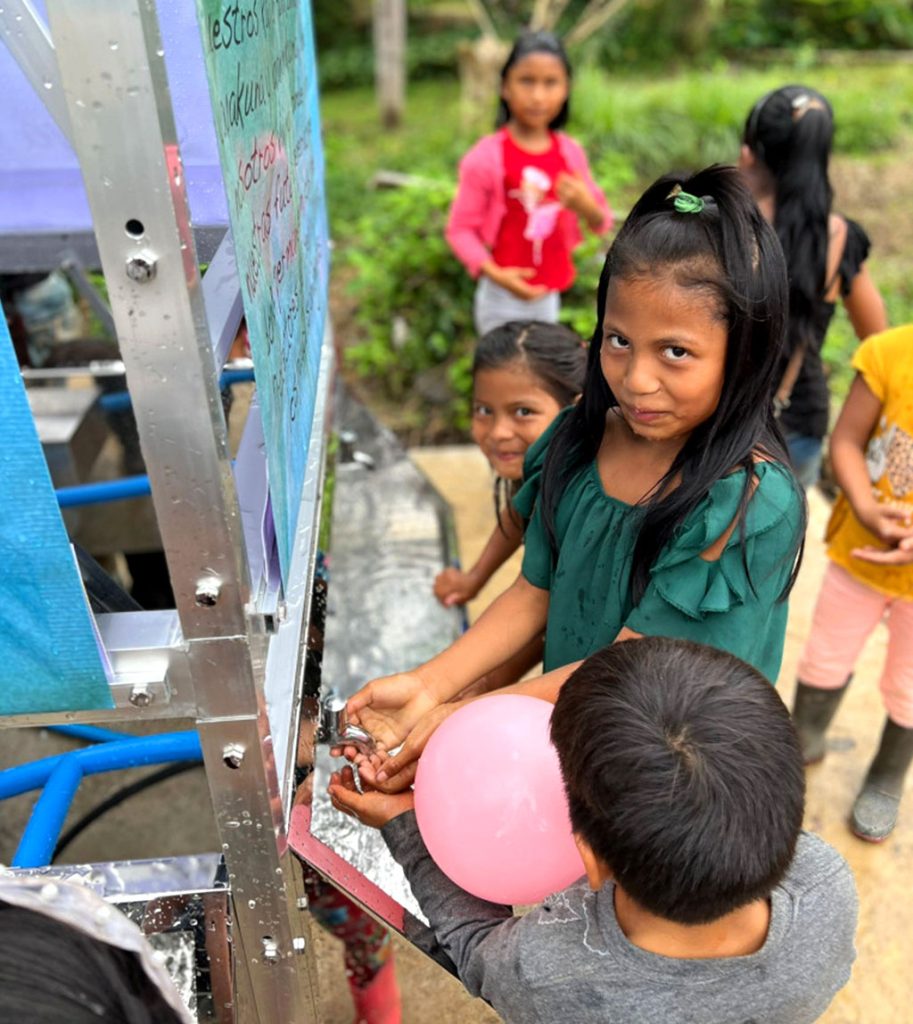 Marbella design academy charity ecuador water project children enjoying safe tap water - Marbella Design Academy